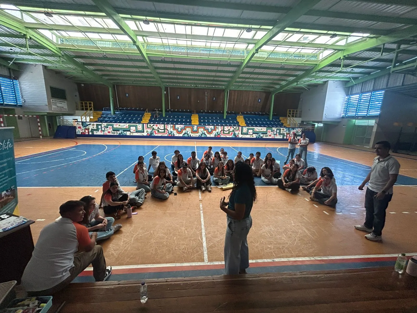 Coach Wen guiando una convivencia grupal con estudiantes en un gimnasio, como parte de los talleres vivenciales de WeLife